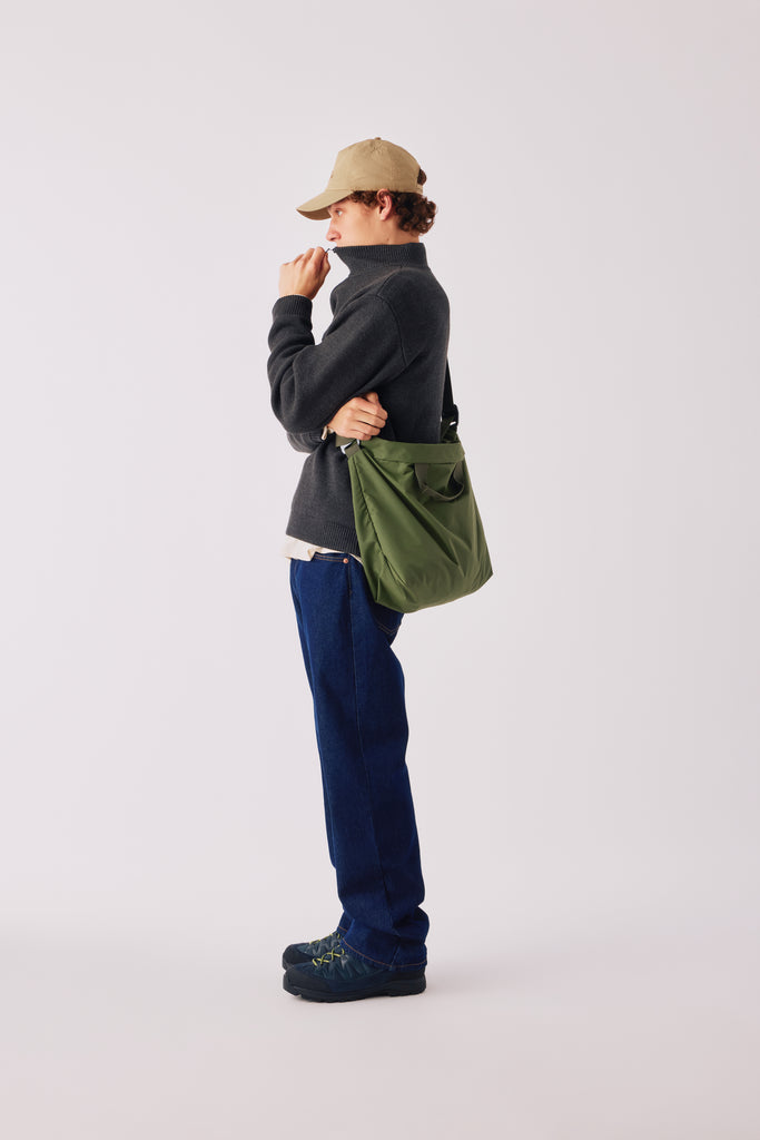FW26 on-model fit reference. Shown: 3/4 Zip Sweater - Dark Heather Grey; Guide Hat - Khaki; Zip Tote - Green. Photograph 25037.