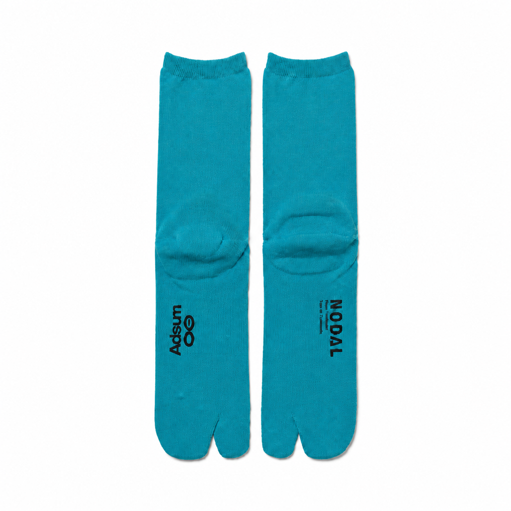 Adsum and NODAL co-branded Turquoise tabi socks on a color-matched white background